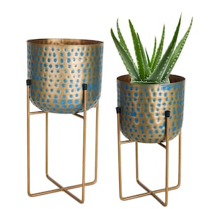 Juego de maceteros de metal texturizado azul hechos a mano con soporte dorado moderno para plantas de interior.