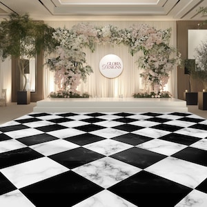 Puede incluir: Un lugar para bodas o eventos con un suelo de mármol a cuadros blancos y negros. Un escenario está decorado con flores y un telón de fondo con el texto "GLORIA DESIGNS". El techo tiene iluminación empotrada.