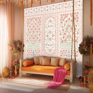 May include: A decorative swing seat with an orange cushion and pillows, set against a floral patterned wall. The wall features pink and green floral designs on a white background. A pink blanket drapes over the swing, and the scene is decorated with flowers.