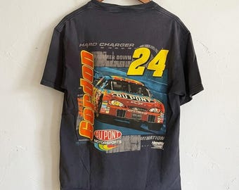 May include: Dark grey t-shirt with a race car graphic, number 24, and the text "Gordon" and "DuPont Motorsports". The design features red, yellow, and blue colours, with the words "Hard Charger" and "Hammer Down".