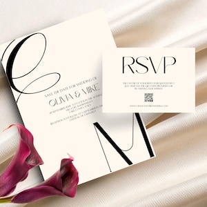 May include: Elegant wedding invitation suite featuring a cream-colored save-the-date card and RSVP card. The save-the-date card includes the names Olivia & Mike, event details, and a large stylized letter. The RSVP card has the word RSVP in bold text.