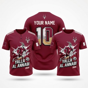 Puede incluir: Camisetas de f&uacute;tbol granates con detalles blancos. Las camisetas presentan un gr&aacute;fico de cabra corriendo, el texto "Yalla Al Annabi 2026" y el n&uacute;mero 10. Una camiseta tiene "YOUR NAME" y el n&uacute;mero 10 en la espalda.