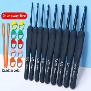 May include: A set of black crochet hooks with varying sizes, ranging from 2.0mm to 6.0mm, with soft grip handles. Includes orange yarn needles and colorful stitch markers. The text "Give away free" and "Random color" are visible.