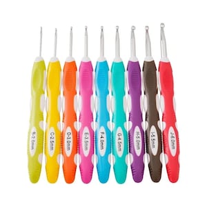 Puede incluir: Un conjunto de nueve ganchillos con mangos coloridos. Cada ganchillo es de un color diferente, que va del verde al rojo, y está etiquetado con un tamaño en milímetros, de 2,0 mm a 6,0 mm. Los ganchillos están dispuestos en fila sobre un fondo blanco.