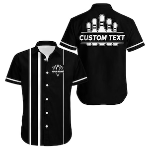 Puede incluir: Camisa de bolos negra con rayas y ribetes blancos. La parte delantera presenta un gráfico de bolos y el texto "YOUR NAME". La parte trasera muestra un gráfico de bolos y el texto "CUSTOM TEXT".