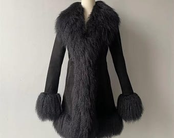 May include: A black coat with a faux fur collar, trim, and cuffs. The coat has long sleeves and a tailored fit. The faux fur is a dark, textured material. The coat is displayed on a mannequin.