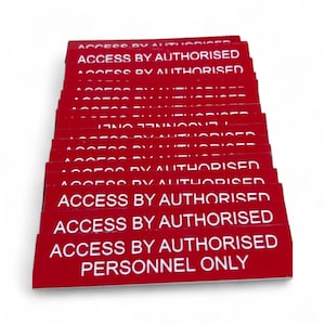 May include: A stack of red rectangular signs with white text. The signs read "ACCESS BY AUTHORISED PERSONNEL ONLY". The signs are likely used for security or access control.