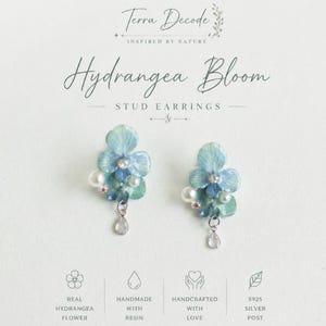 Könnte beinhalten: Ein Paar Ohrstecker mit einem Design aus blauen Hortensienblüten. Die Ohrringe haben Perlen- und Kristallakzente sowie einen tropfenförmigen Anhänger. Der Text auf dem Bild lautet "Hydrangea Bloom" und "Stud Earrings".
