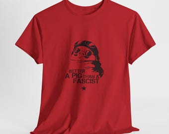 Può includere: T-shirt rossa con grafica nera di un maiale con occhiali e sciarpa. Il testo "BETTER A PIG THAN A FASCIST" è stampato sotto, con una stella in basso.
