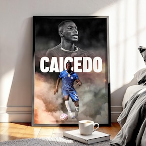 May include: Framed poster featuring a soccer player in a blue uniform, with the name "CAICEDO" in large white letters. The image has a black and white portrait of the player at the top and a full-body action shot below, with a smoky background.