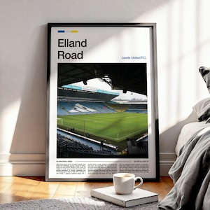 Puede incluir: Póster enmarcado con una vista del estadio de Elland Road, sede del Leeds United F.C. La imagen muestra el campo verde, los asientos azules y la arquitectura del estadio. El póster incluye el texto "Elland Road" y "Leeds United F.C."