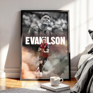 Può includere: Poster incorniciato con un calciatore in maglia nera e rossa, con il nome "EVANLSON" in bianco. L'immagine ha uno sfondo fumoso e include due immagini aggiuntive del giocatore in scala di grigi.