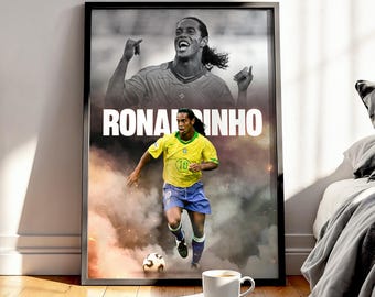Puede incluir: Póster enmarcado con el futbolista Ronaldinho. La mitad superior es una imagen en blanco y negro de Ronaldinho con los brazos levantados. La mitad inferior muestra a Ronaldinho con una camiseta amarilla y pantalones cortos azules, pateando un balón de fútbol. La palabra "RONALDINHO" está en letras blancas grandes.