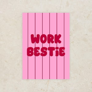 Peut inclure: Une carte rose avec des rayures verticales rose foncé. Les mots "WORK BESTIE" sont écrits dans une police en gras, de style bulle, dans une nuance de rose plus foncée.