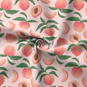 Pode incluir: Um tecido com um padrão repetido de pêssegos, fatias de pêssego e metades de pêssego sobre um fundo rosa claro. Os pêssegos são de uma cor rosa-alaranjada suave com folhas verdes. O design é em estilo aquarela.