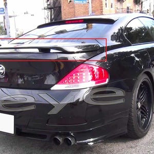 Pode incluir: Um carro preto com um spoiler traseiro, luzes traseiras e tubos de escape duplos. O carro tem jantes pretas e está estacionado numa rua da cidade. O spoiler está montado na mala.