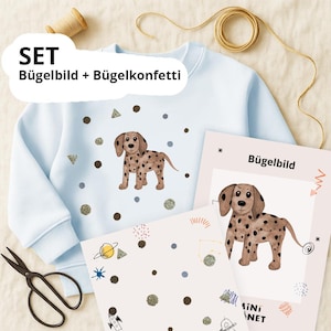 Puede incluir: Sudadera azul claro con un diseño de perro dálmata y detalles de purpurina. La imagen incluye una transferencia de planchado y confeti, con el texto "SET Bügelbild + Bügelkonfetti".