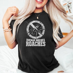May include: Black t-shirt with a distressed graphic of a cockroach inside a circle with a line through it. The text "BUENAS NOCHES ROACHES" is printed below the graphic in a distressed font.