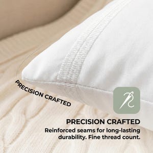 May include: Close-up of a white pillow with reinforced seams. The pillow has a stitched border and the words "PRECISION CRAFTED" are printed on the image. The image also includes a graphic of a needle and thread.