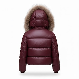 K&ouml;nnte beinhalten: Burgunderfarbene Pufferjacke mit Kapuze mit Kunstfellbesatz. Die Jacke hat ein gestepptes Design und ein gl&auml;nzendes Finish. Die Kapuze ist mit braunem Kunstfell gef&uuml;ttert. Warme Winterjacke f&uuml;r kalte Tage.