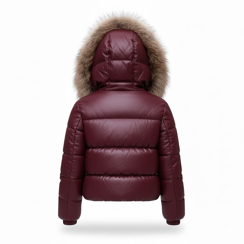 K&ouml;nnte beinhalten: Burgunderfarbene Pufferjacke mit Kapuze mit Kunstfellbesatz. Die Jacke hat ein gestepptes Design und ein gl&auml;nzendes Finish. Die Kapuze ist mit braunem Kunstfell gef&uuml;ttert. Warme Winterjacke f&uuml;r kalte Tage.