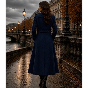 May include: A long, dark navy blue wool-blend coat featuring a structured collar, shoulder epaulets, and a fitted waist with a horizontal back tab detail. The coat has long sleeves and a flared, floor-length skirt, paired with black leather boots.