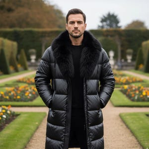 Könnte beinhalten: Ein langer, schwarzer Steppmantel mit Pelzkragen. Der Mantel ist zugeknöpft und hat Taschen. Die Person steht in einem Garten mit einem Weg und Blumenbeeten.