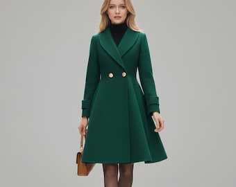 May include: A forest green double-breasted coat with gold buttons. The coat has a flared skirt and a notched collar. The person is wearing a black turtleneck and carrying a brown handbag. The coat's length is approximately 102 cm.