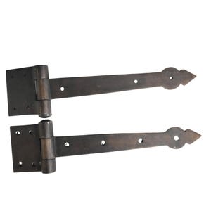 Könnte beinhalten: Zwei antik anmutende Scharniere in dunkler Bronze. Jedes Scharnier hat eine rechteckige Montageplatte mit mehreren Schraubenlöchern und einen langen, sich verjüngenden Arm, der in einer dekorativen Pfeilspitze endet. Für Türen oder Tore.