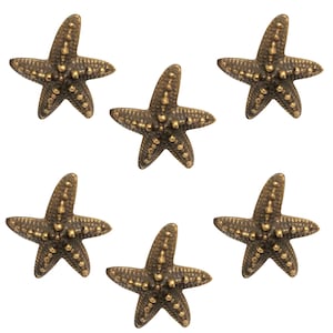 Op de afbeelding: Zes bronzen zeesterdecoraties met een textuuroppervlak en kleine, goudkleurige accenten. De zeesterren zijn gerangschikt op een witte achtergrond. Deze decoratieve zeesterren zijn ideaal voor een kust- of nautisch thema.