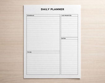 Puede incluir: Una hoja de planificador diario blanca con el título "DAILY PLANNER" en la parte superior. El planificador incluye secciones para horario, principales prioridades, tareas y notas, todas con espacios rayados para escribir. El planificador está sobre una superficie de madera clara.