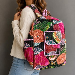 Puede incluir: Una mochila acolchada con un vibrante patrón floral y abstracto multicolor sobre un fondo negro. La bolsa incluye un bolsillo frontal con solapa, bolsillos laterales y correas ajustables para los hombros, todo con ribetes blancos y rosas.