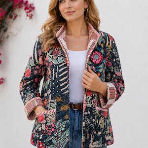 May include: A quilted jacket featuring a dark navy base with a vibrant, multi-coloured floral and animal print pattern. The jacket has a stand-up collar, long sleeves with folded cuffs, two front patch pockets, and a striped trim along the edges.