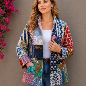 May include: A patchwork jacket with a variety of colorful patterns, including floral, striped, and geometric designs. The jacket has a quilted texture, a collar, and pockets. The model is wearing blue jeans and a white top.