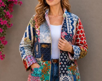 May include: A quilted jacket featuring a vibrant patchwork design with various floral, animal, and geometric patterns in shades of red, blue, green, and white. The jacket has a stand-up collar, long sleeves, and two front pockets, worn over a white top.