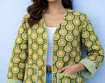 May include: A quilted jacket featuring a green background with a repeating yellow and white floral pattern. The jacket has a V-neckline, long sleeves with green and white striped cuffs, and two front patch pockets with matching striped trim.