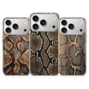 Op de afbeelding: Drie smartphonehoesjes met verschillende slangenhuiddessins. Het linkerhoesje heeft een bruin en zwart schubbenpatroon, het middelste hoesje toont een donkerbruin en zwart patroon en het rechterhoesje heeft een beige en groene textuurprint.