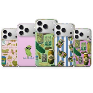 May include: Five smartphone cases featuring pickle-themed designs. One is pink with a pickle wearing sunglasses and the text 'just dill with it'. Others display patterns of pickle jars, whole pickles, and pickle slices on pink, green, and blue striped backgrounds.