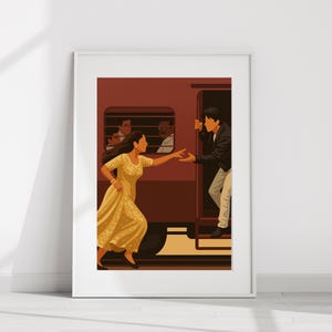 Puede incluir: Una impresión artística enmarcada representa a una mujer con un vestido amarillo extendiendo la mano hacia un hombre que sale de un tren. El hombre lleva una chaqueta negra y pantalones claros. El tren es granate, con pasajeros.