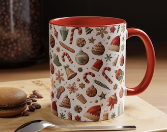 May include: A white ceramic mug with a bright red interior and handle, featuring a repeating pattern of Christmas-themed illustrations including candy canes, ornaments, Santa hats, bells, snowflakes, and gift boxes in red, green, and tan.