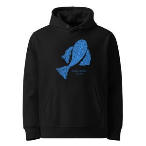 May include: Black hooded sweatshirt with a blue fish-shaped design on the front. The design is intricate, with detailed lines. The text "Ursus Atelier Est. 2023" is below the fish. The sweatshirt has a front pocket.