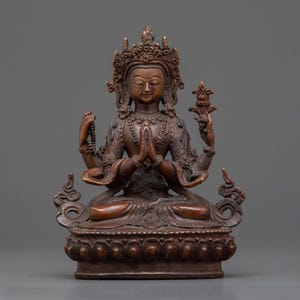 Puede incluir: Estatua de bronce de una deidad sentada con múltiples brazos, adornada con una corona y joyas intrincadas. La figura está en una pose meditativa, con las manos juntas en oración. La estatua tiene tallas detalladas y se asienta sobre una base decorativa.