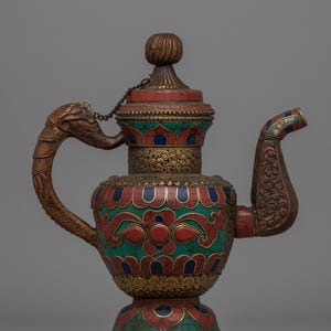 May include: An antique teapot with an elaborate design. The teapot has a brown dragon-head handle, a spout with colourful accents, and a lid with a decorative knob. The body is decorated with red, green, and blue mosaic-like patterns, and gold trim.