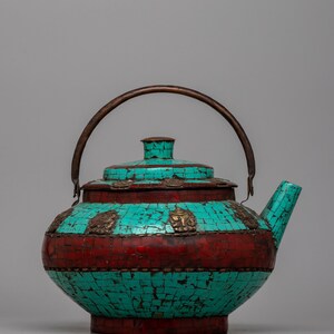 Peut inclure: Théière décorative avec un motif en mosaïque turquoise et rouge. La théière a une poignée incurvée et un bec verseur. Le couvercle et le corps sont ornés d'éléments métalliques. Un objet de décoration unique.