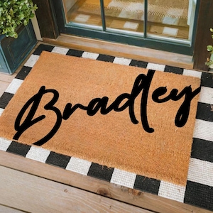 May include: A rustic wooden sign with the text "Welcome to our home" in a handwritten style. The sign features a distressed finish and a simple, inviting design, perfect for a front porch or entryway.