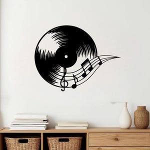 Puede incluir: Silueta negra de un disco de vinilo con notas musicales y una clave de sol. El diseño muestra los surcos del disco y un pentagrama. Un elemento decorativo para los amantes de la música.