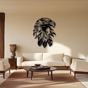 May include: A black metal eagle head wall art piece. The eagle is depicted in profile, with detailed feathering and a sharp beak. The artwork is mounted on a neutral-colored wall in a living room setting, adding a touch of nature-inspired decor.