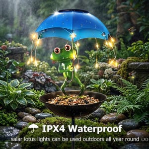 May include: A decorative garden ornament of a green frog holding a blue umbrella with fairy lights. The frog stands in a dark brown bowl filled with pebbles. The text "IPX4 Waterproof" is visible. The lights can be used outdoors all year round.