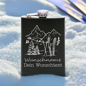 Könnte beinhalten: Schwarze Edelstahlflasche mit Berg- und Skidesign. Die Flasche hat einen silbernen Deckel und einen Klappverschluss. Auf der Vorderseite der Flasche stehen die Worte "Wunschname Dein Wunschtext" in Weiß.