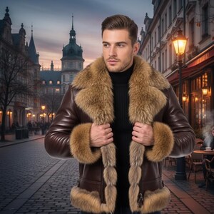 Op de afbeelding: Een bruine leren jas met een bontkraag en manchetten. De jas heeft een ritssluiting en wordt gedragen over een zwarte coltrui. De vacht is lichtbruin van kleur. De jas wordt gedragen door een persoon op een geplaveide straat.